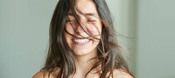 Feeling fresh and confident Close-up portrait of a beautiful girl smiling with her hair blowing in wind eyes closed stock pictures, royalty-free photos & images