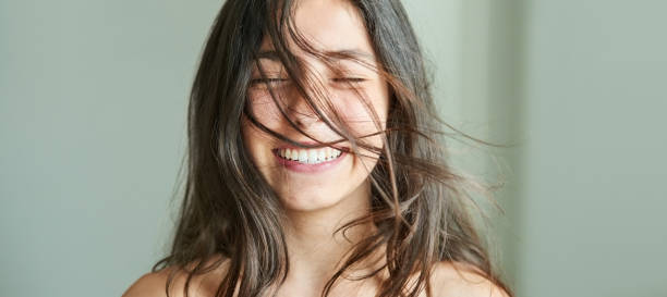 Feeling fresh and confident Close-up portrait of a beautiful girl smiling with her hair blowing in wind Toothy Smile stock pictures, royalty-free photos & images