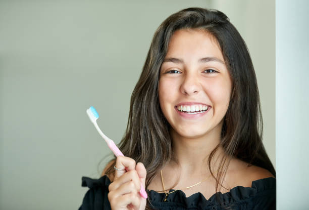 brush your way to a beautiful smile - brushing teeth women toothbrush brushing imagens e fotografias de stock