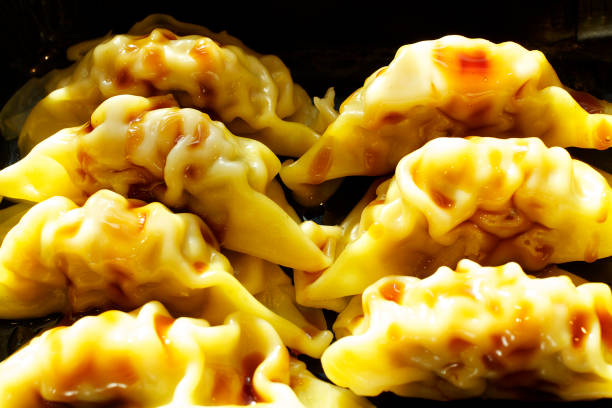 A plate of authentic Japanese gyoza dipping with sauce.
