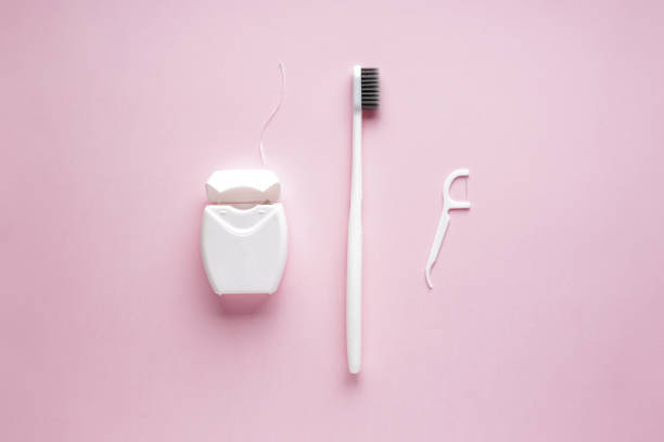 ピンクの背景につまようじを持つ歯ブラシとフロス。フラットレイ構成。 - floss toothpick ストックフォトと画像