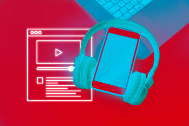 Woman's hands with fashionable manicure and gold rings holding white headphones and connected smart phone with blank screen, top view. Listen to music concept flat lay on uniform turquoise background.