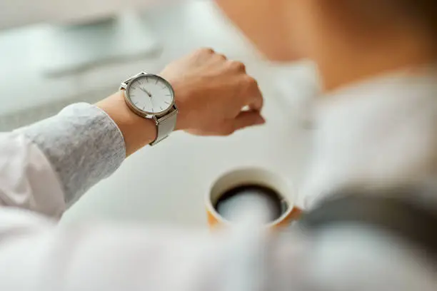 Photo of Close-up of businesswoman checking time on her wristwatch.