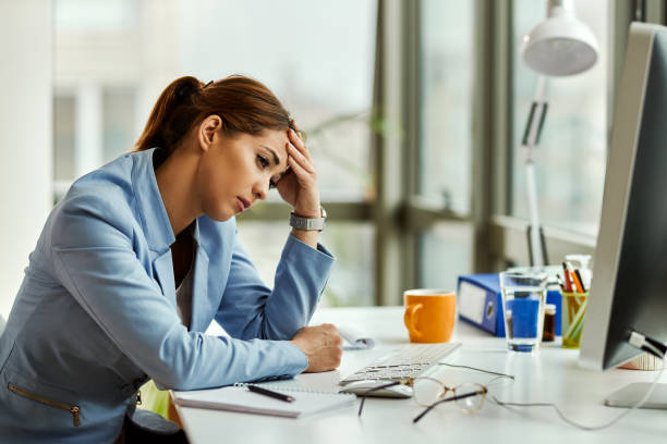 istock Young distraught businesswoman thinking while sitting at her office desk. 1219617232