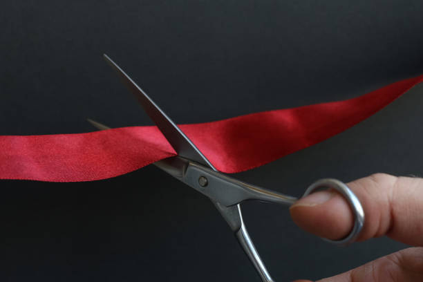 бизнесмен разрезает ножницами ленту - business opening beginnings ribbon cutting стоковые фото и изображения