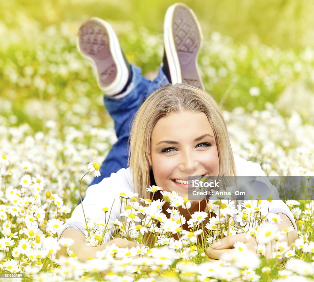 Chica feliz disfrutando de campo de flor Margarita - Foto de stock de Acostado libre de derechos