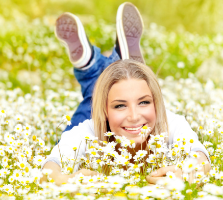 Cute happy girl enjoying daisy flower field, nature at summertime, leisure fun outdoor