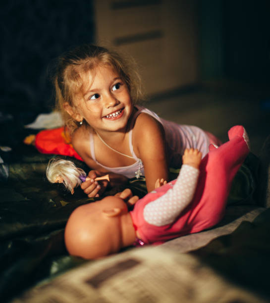 istock Happy Little Girl Playing with Dolls 1219624961