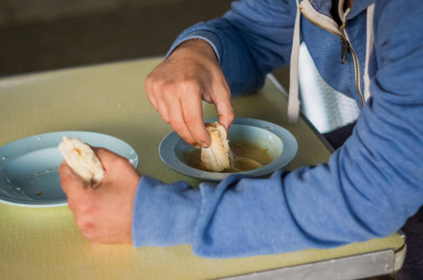 Man eating soup Closeup of a man eating soup at a soup kitchen. emergency shelter photos stock pictures, royalty-free photos & images