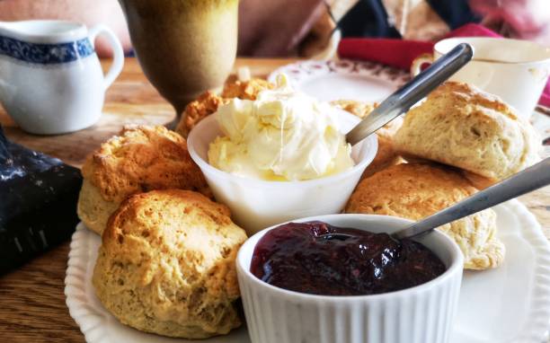 Cream scones and jam A plate of scones with jars of clotted cream and jam. Image taken with an Huawei P20 Pro mobile phone. scone photos stock pictures, royalty-free photos & images