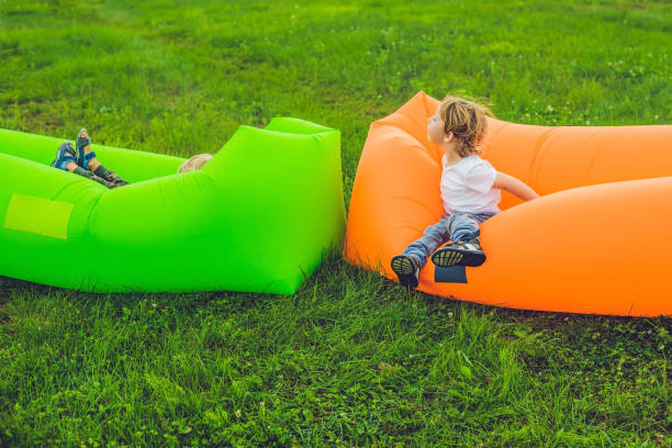 istock Two cute boys resting on an air sofa in the park. 1219630263