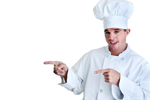 Chef shot on white background pointing to copy space