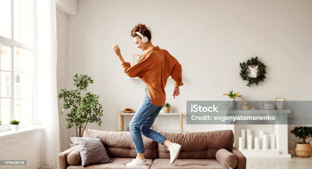 쾌활한 여자는 음악을 듣고 하루에 집에서 부드러운 소파에 춤을 - 로열티 프리 춤 스톡 사진