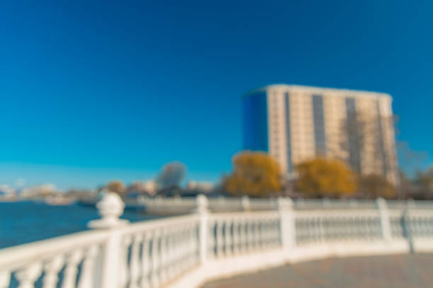 istock unfocused abstract modern green city idyllic river waterfront district with white fence and building frame silhouette in vivid colorful summer day time 1219638497