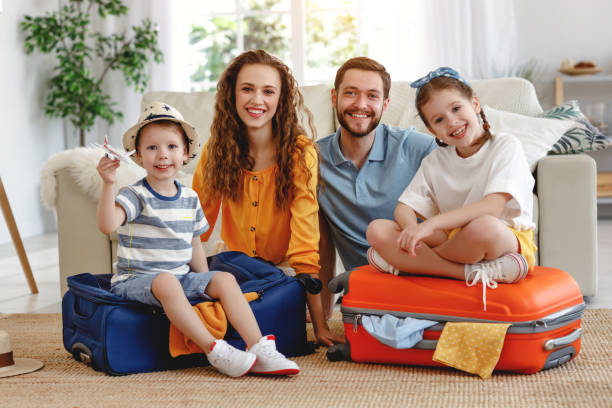 istock Cheerful family with suitcases on floor looking at camera 1219639283