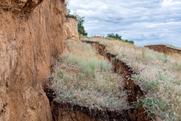 glissement de terrain avec des fissures dans le sol, la terre de fracture a coulé vers le bas, la terre sûre de l’environnement. - quake damaged section photos et images de collection