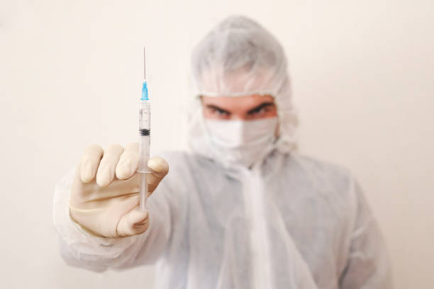 Coronavirus stop infection. young male doctor with syringe. infectious diseases and flu. Healthcare, medical education, emergency medical service, surgery concept. infectious diseases doctor on white. enfermedades infecciosas doctor en blanco. el coronavirus detiene la infección. médico varón joven con jeringa. enfermedades infecciosas y la gripe. cuidado de la salud, educación médica, servicio médico de emergencia, concepto de cirugía.