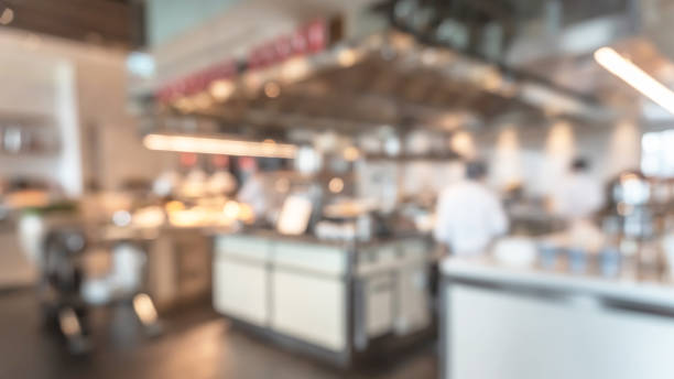 Buffet at hotel restaurant interior blur background with blurry open kitchen counter bar of food catering service business with chef staff cooking for breakfast, lunch or dinner meal