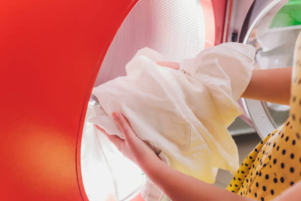 hands to load the laundry in the washing machine at the dry cleaners. - water human hand stream clean imagens e fotografias de stock