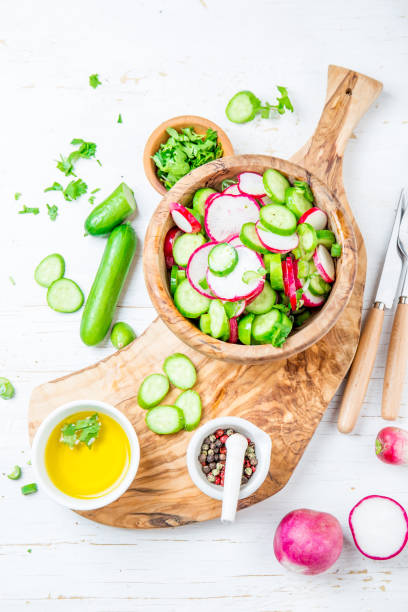istock Fresh radish cucumber salad, white background. Top view 1219642294