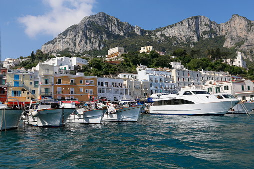 Island of Capri, Italy - may 20, 2014 - view of boat harbor or Marina Grande, on the Island of Capri, with colorful buildings in the background, a major tourist destination near Naples and Sorrento on the Tyrrhenian Sea, Bay (Gulf) of Naples.