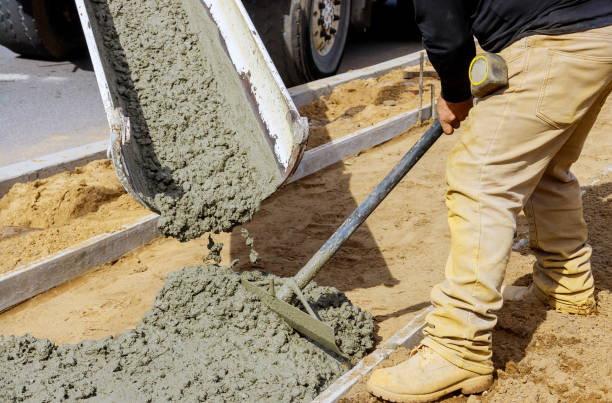 istock Construction worker pour cement for sidewalk in concrete works with mixer truck with wheelbarrow 1219646133