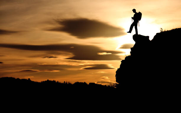 istock Silhouette of a Young Hiker With Backpack and Poles On Hoodoo Making Dangerous Step Into Thin Air 1219648615