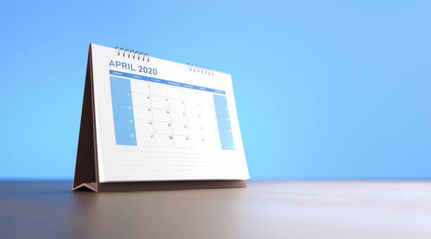 istock 2020 Monthly Blue Desk Calendar on Wood Surface: April 1219649981