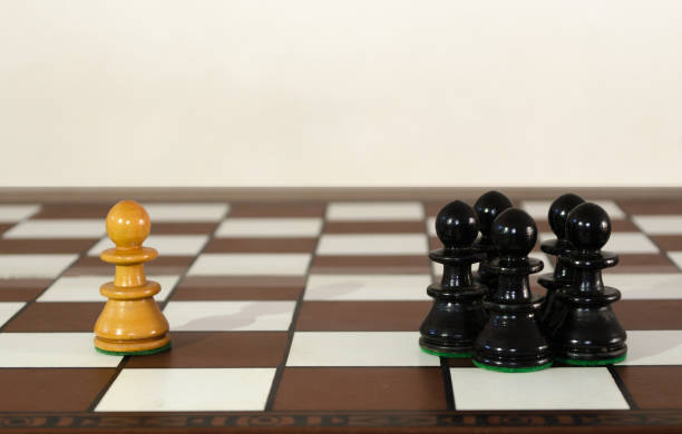 istock Wooden chess pieces grouped and single one. Bullyng and discrimination concept. 1219653269