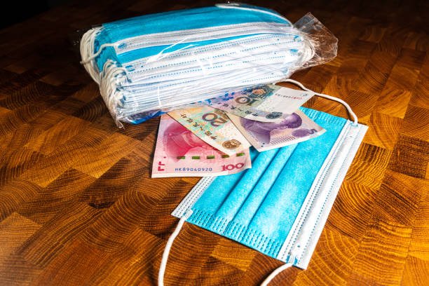 istock Face mask and money on the table 1219661080