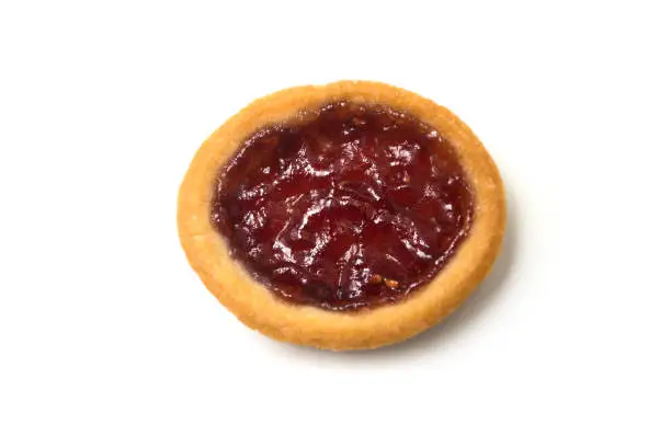 Closeup of mini tartlet with strawberry jam on top view on white background