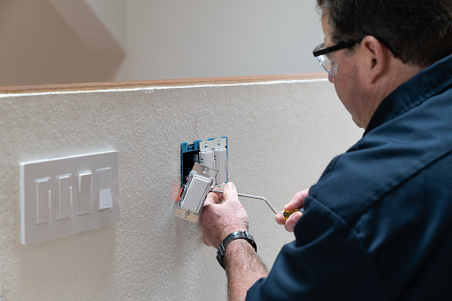 Electrician installing light switch