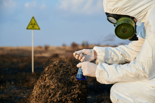 istock Researcher in protective suit working on a burnt field taking samples of flora 1219673230