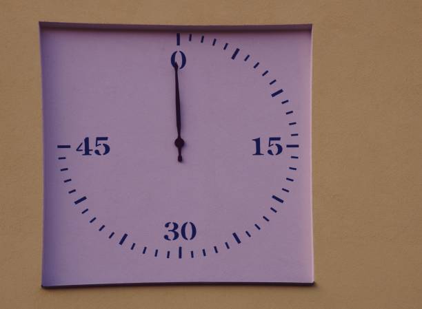 Forty-five-minute stopwatch for measuring a football match. Traditional score board at stadium. Outside, athlete.