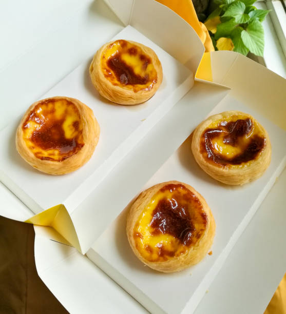 egg tart on food wrapping paper - creme brulee tart custard dessert imagens e fotografias de stock