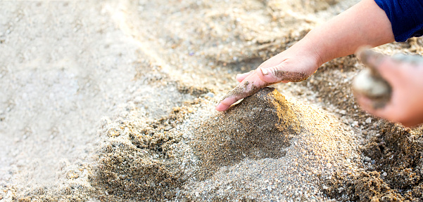 child's hands and sandbox play with sand and copy space. Sand art and play.