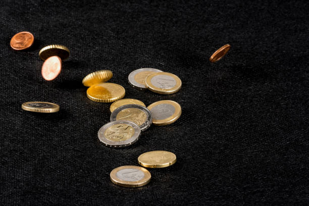 istock Euro coins falling and lying on the black background 1219682478