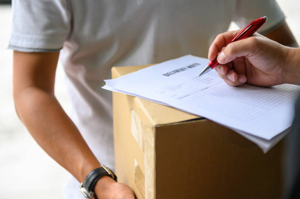 istock Man signing delivery note from deliveryman 1219682722