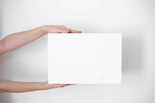istock A parcel cardboard box in a delivery man hands on a white background. Delivery service concept. 1219684815