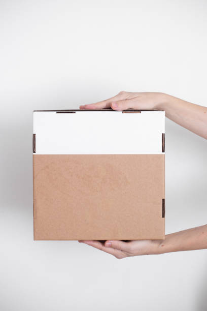 istock A parcel cardboard box in a delivery man hands on a white background. Delivery service concept. 1219684847