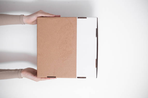 istock A parcel cardboard box in a delivery man hands on a white background. Delivery service concept. 1219684853