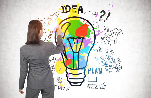 istock Woman drawing business idea sketch on wall 1219685762