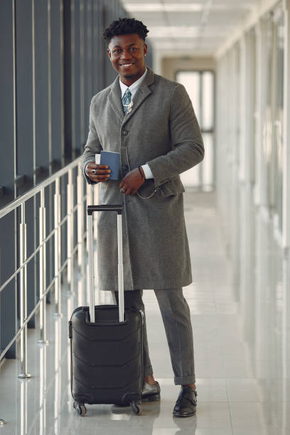 istock Elegant black man at the airport with a suitcase 1219689155