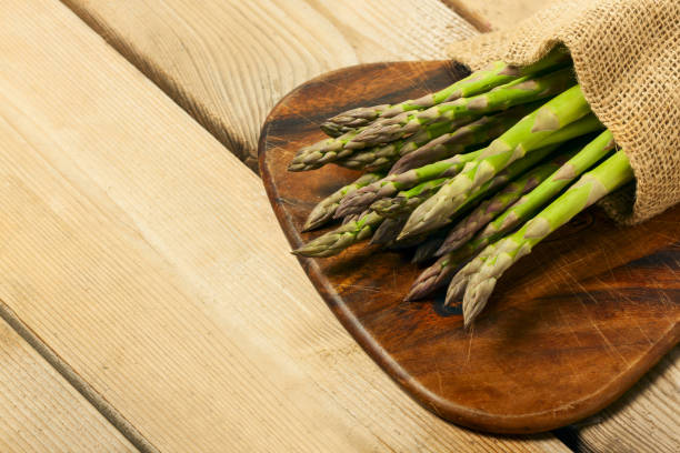 istock Sparrow grass. Fresh green asparagus on black slate background. Top view copy space. 1219691717