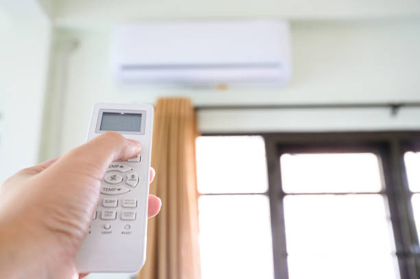 istock Concept of save power energy save sustainability world. Hand push down button air conditioner remote and turning off working machine 1219691984