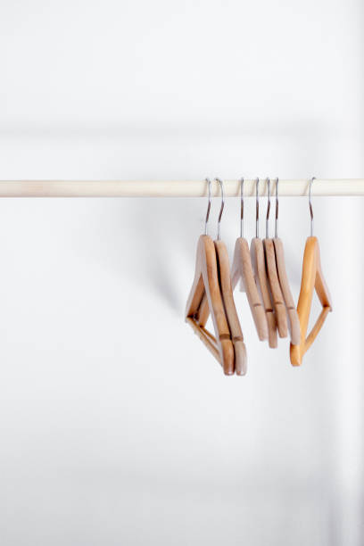 istock wooden hangers on wooden pole with a white background. 1219692097