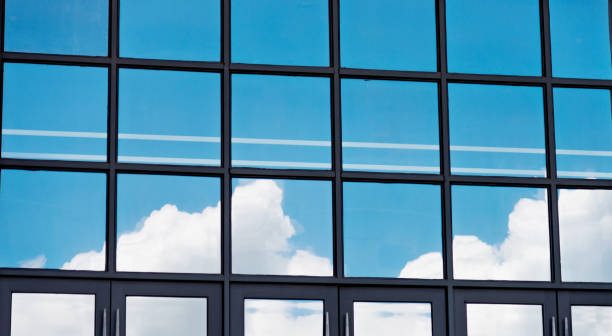 istock Blue sky reflected on wall of modern office building 1219693004