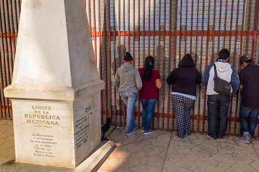 Playas de Tijuana, Mexico, January 25 - Some people leaned against the iron wall on the border between the United States and Mexico in Tijuana, while talking to other people on the other side of the wall.