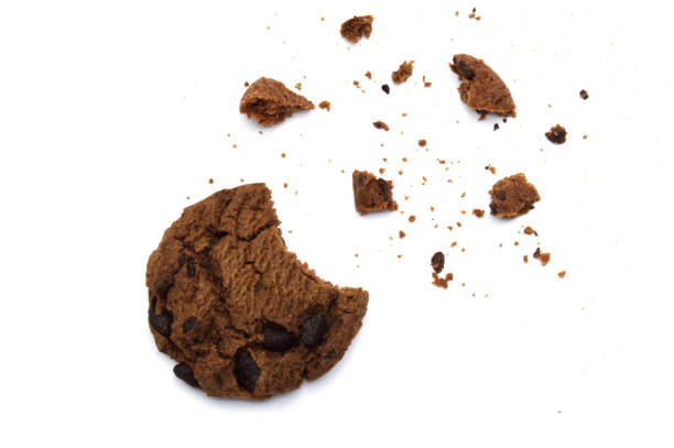 istock Chocolate chip cookies with some broken and crumbs isolated on white background. 1219695447