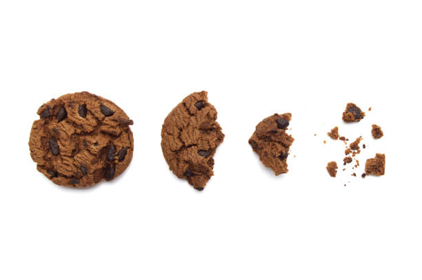 istock Chocolate chip cookies with some broken and crumbs isolated on white background. 1219695553
